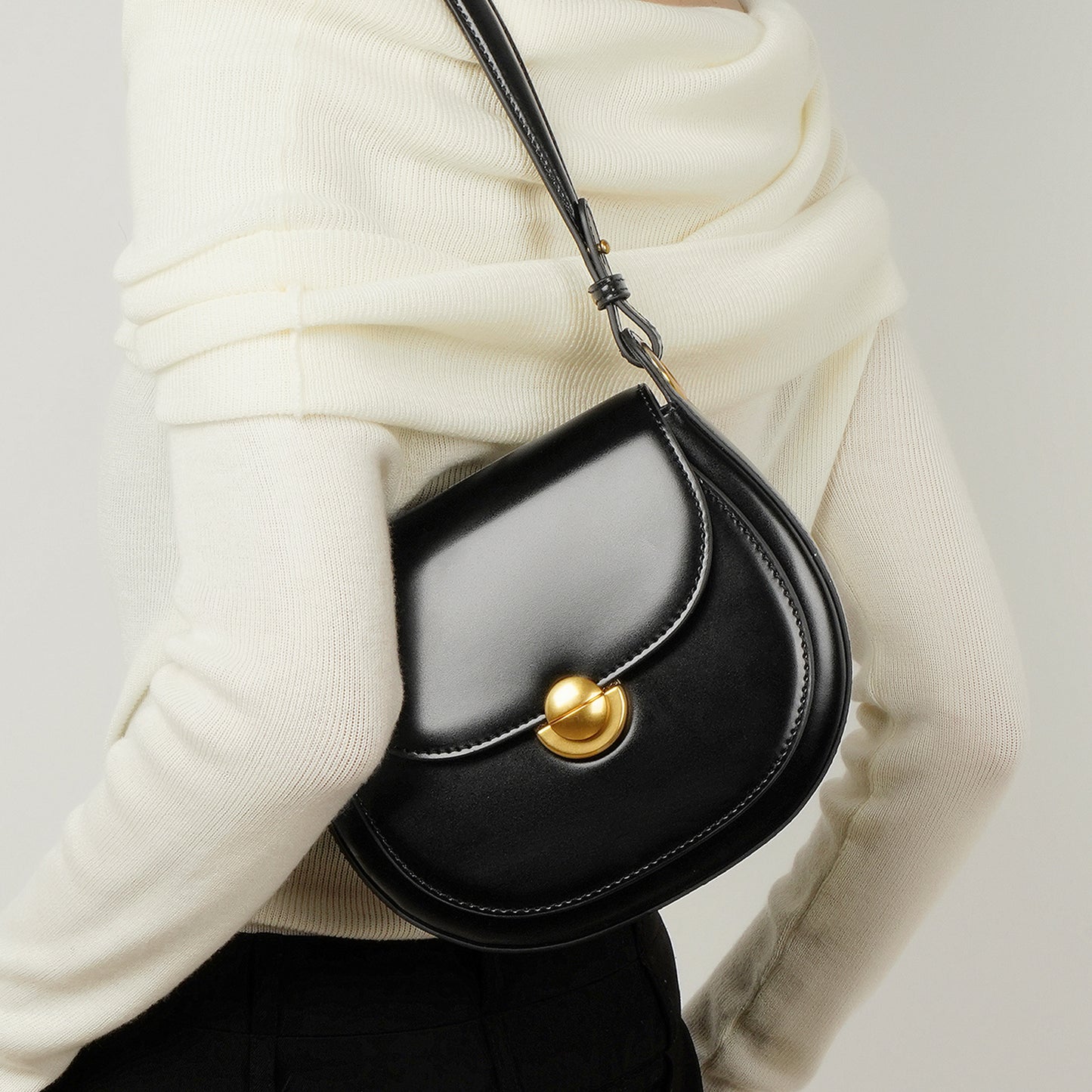 Bolsa de piel minimalista de mano con broche dorado y correa ajustable